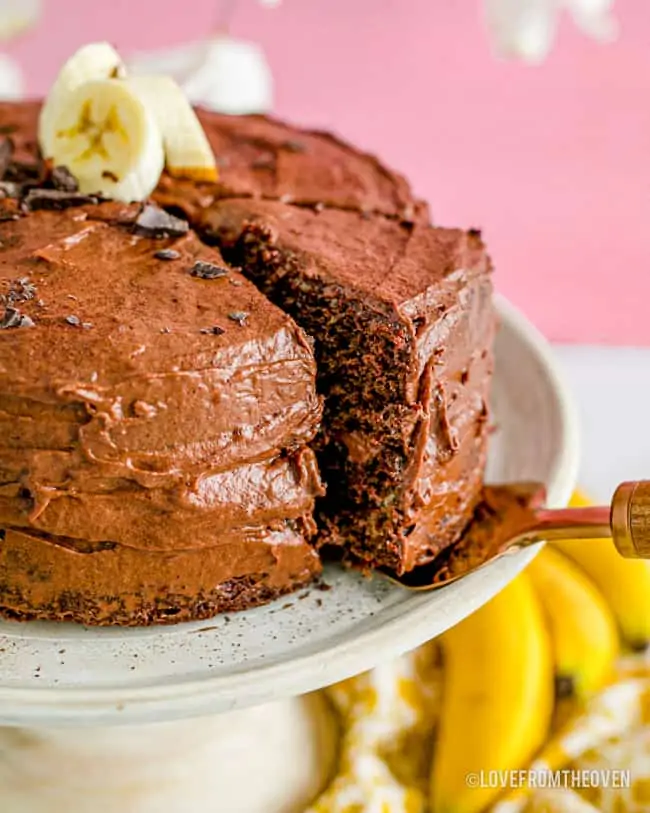 A slice of cake being taken from a chocolate banana cake