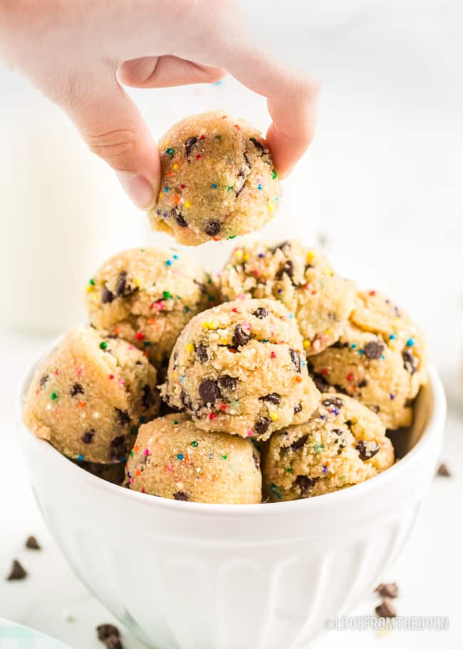 A hand grabbing a cookie dough bite