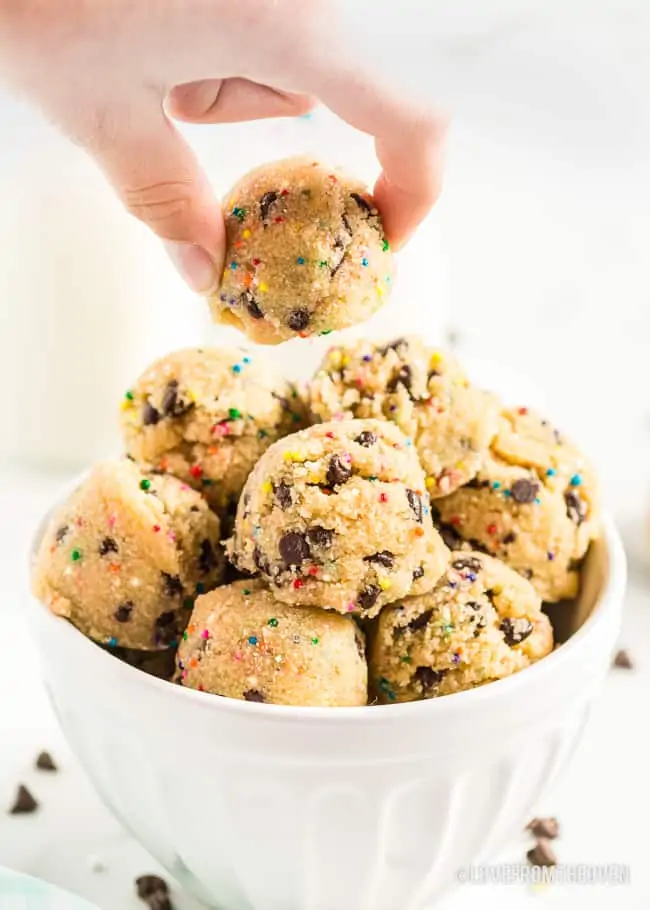 A hand grabbing a cookie dough bite