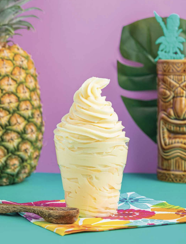 a cup of homemade dole whip with a pineapple in the background