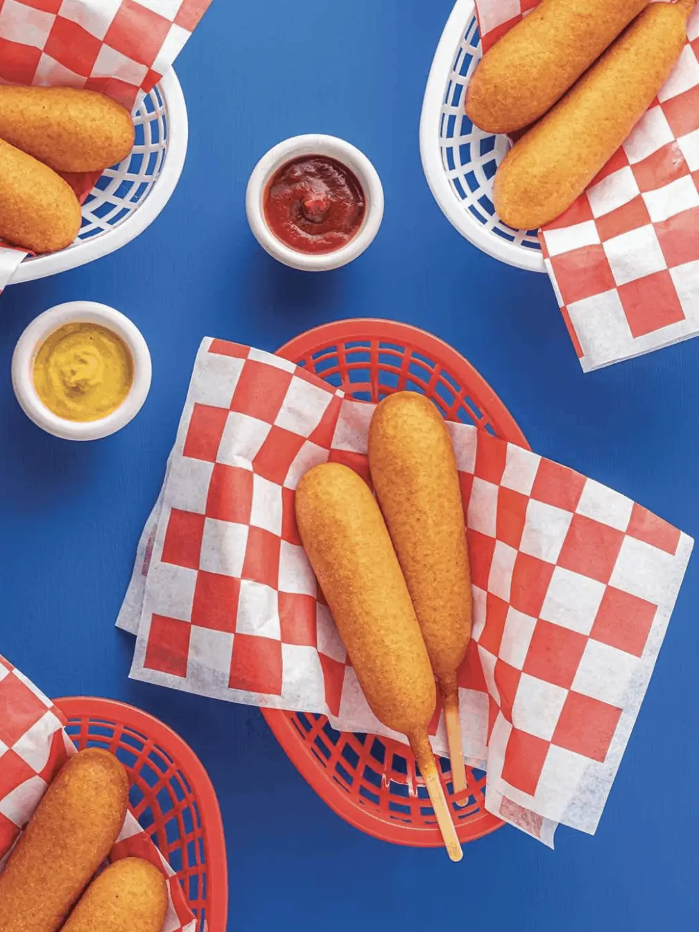 corndogs in baskets with red and white wax paper underneath them