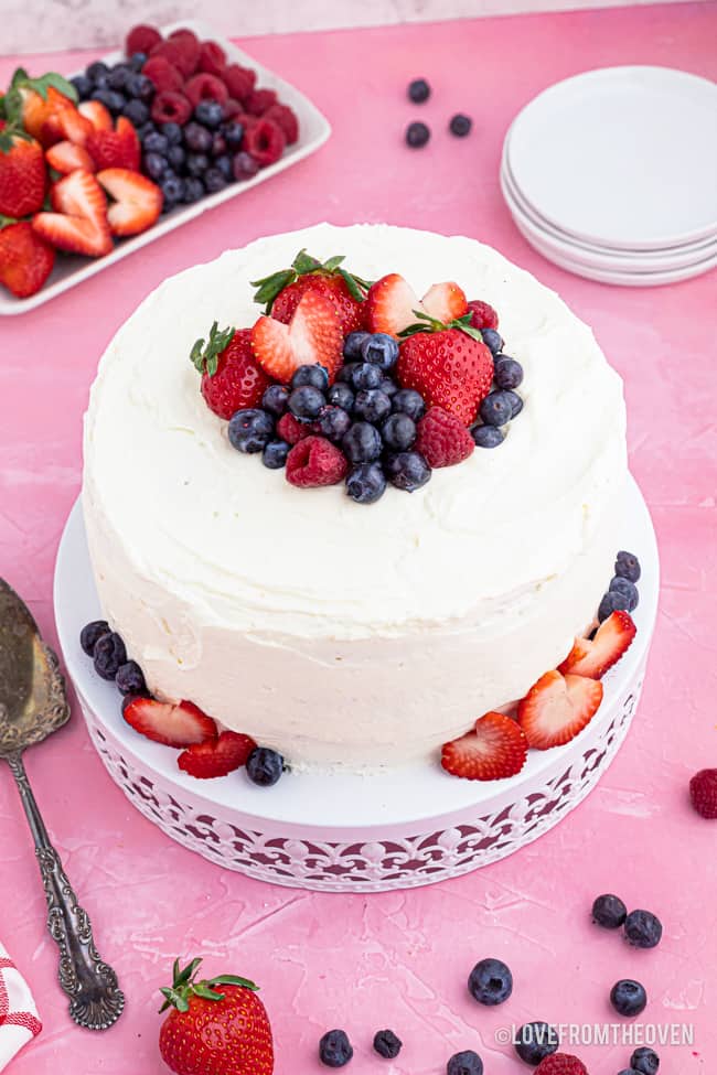 A frosted chantilly cake on a pink background