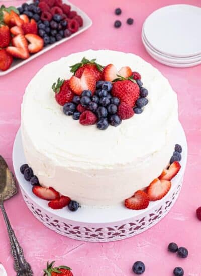 A frosted chantilly cake on a pink background