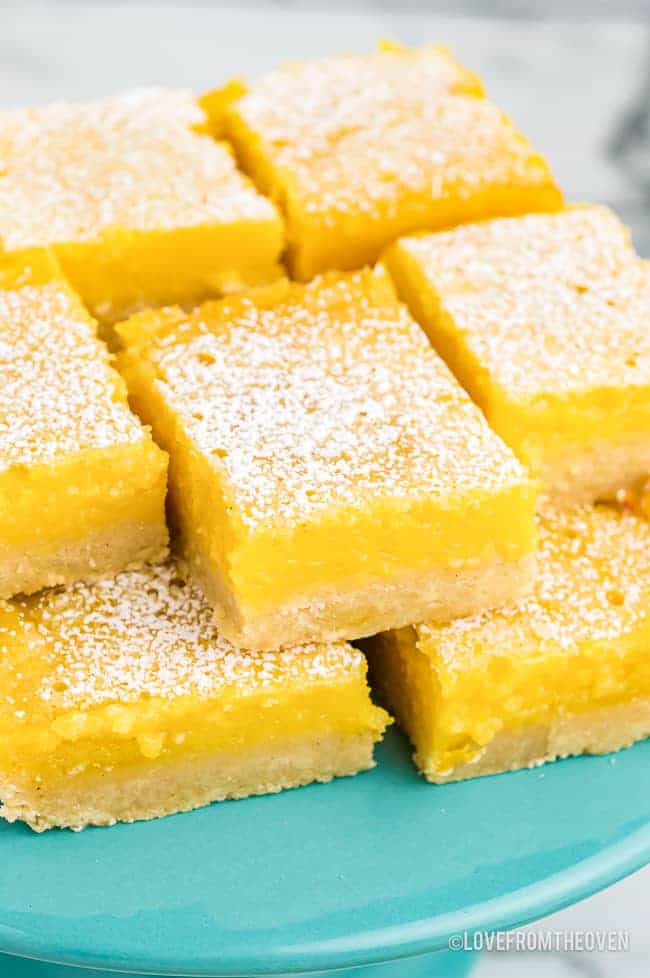 lemon bars on a blue cake plate