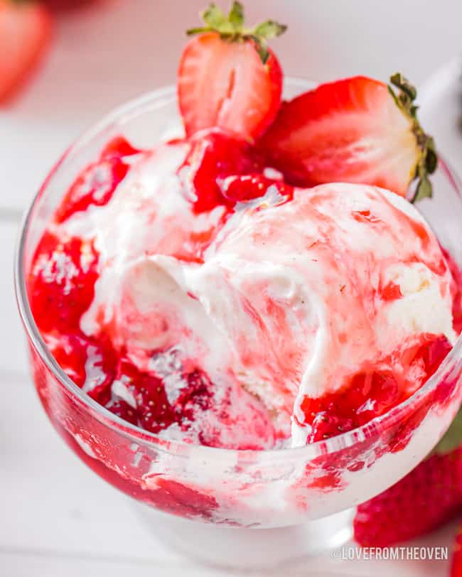 Bowl of ice cream with strawberries and sauce