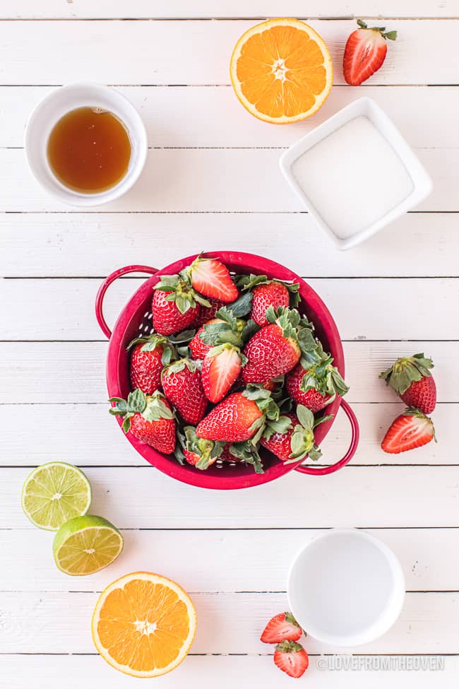 ingredients for strawberry sauce on a white background