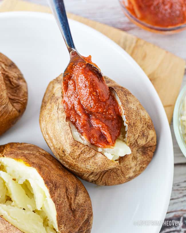 a baked potato having toppings added