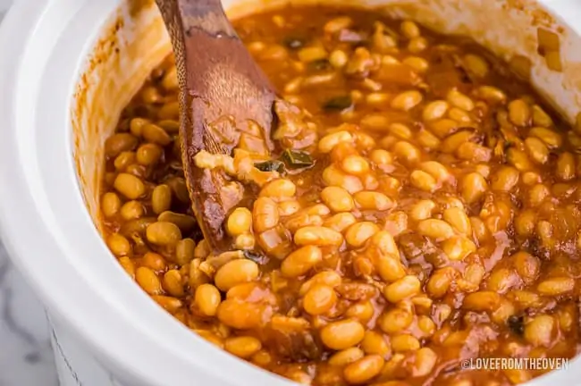 a close up of homemade baked beans in a white crockpot