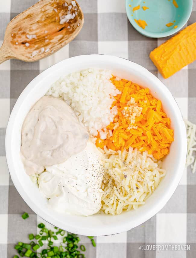 a bowl of ingredients to make cheesy hash browns