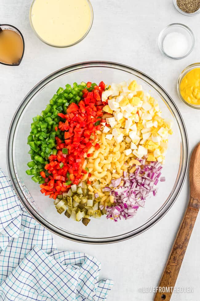 a bowl of ingredients for macaroni salad