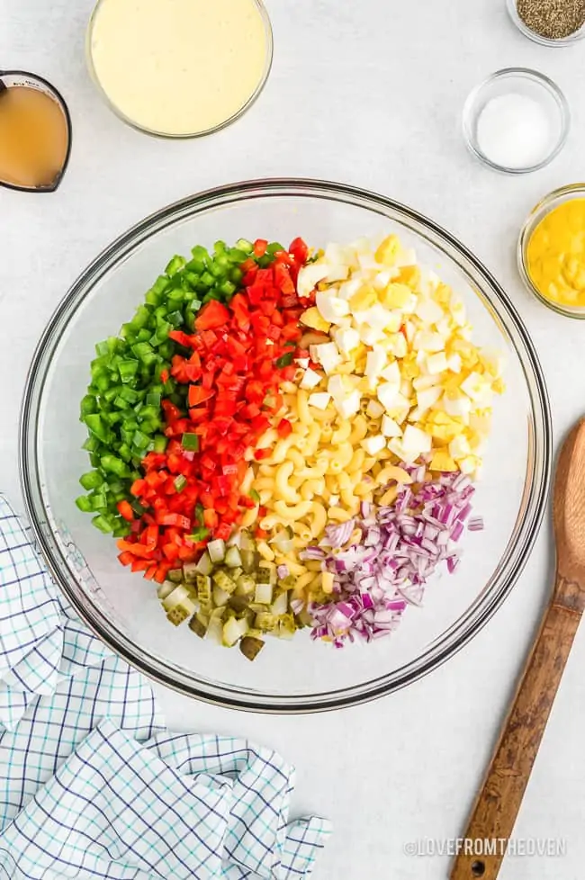 a bowl of ingredients for macaroni salad