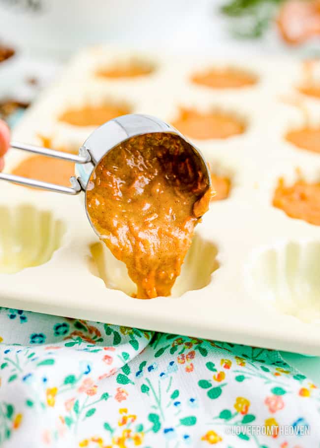 cake batter being scooped into a mini bundt cake pan