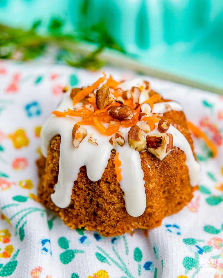 A mini carrot cake on a floral napkin.