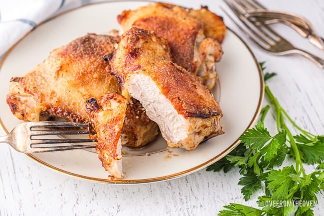 a cooked chicken thigh on a white plate