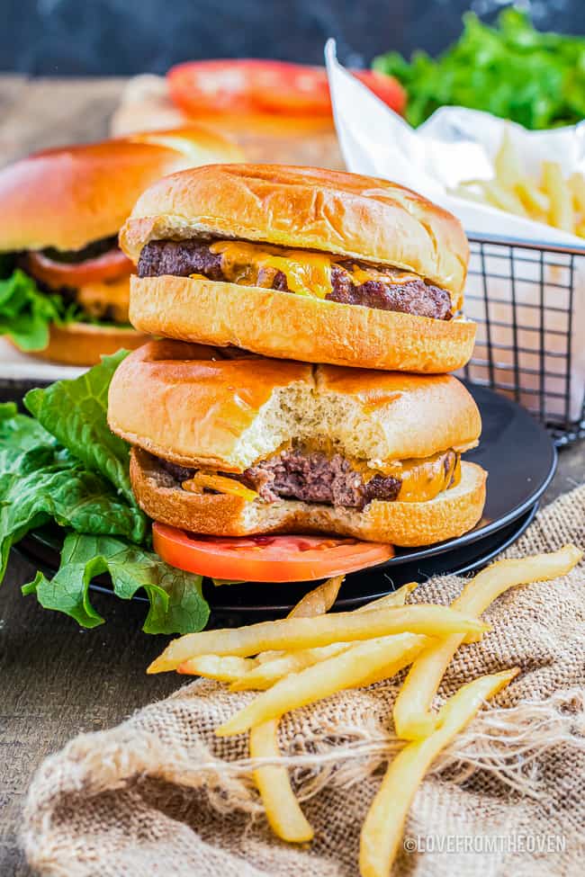 two air fryer cheeseburgers stacked and some french fries