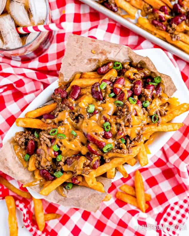 a basket of chili cheese fries on a red and white tablecloth