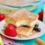 churro cheesecake on a white plate next to a strawberry