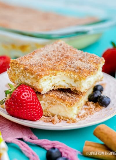 churro cheesecake on a white plate next to a strawberry