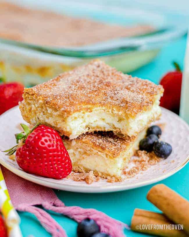 churro cheesecake on a white plate next to a strawberry