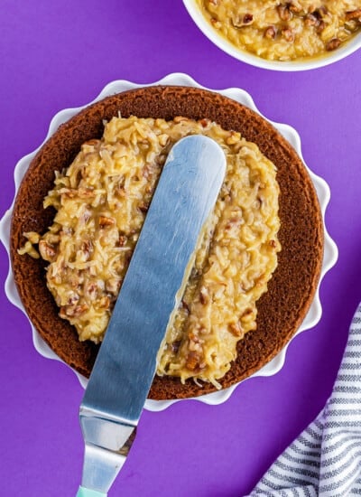 coconut pecan frosting being spread on a German chocolate cake