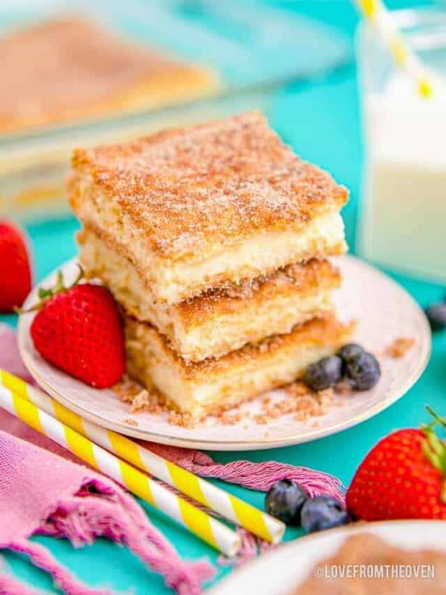 a stack of cheesecake bars topped with cinnamon and sugar
