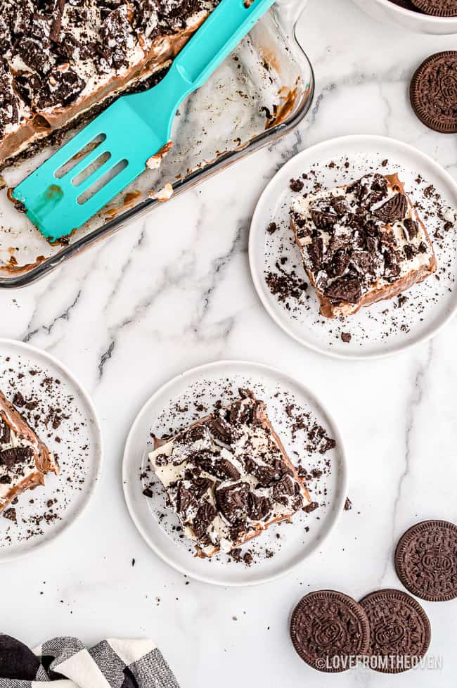 An oreo dirt cake being served onto white plates