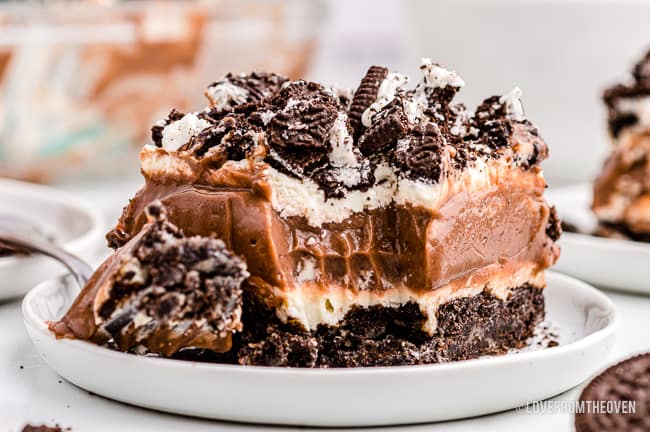 A close up of a slice of dirt cake on a white plate