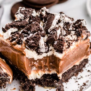 a slice of oreo dirt cake on a white plate