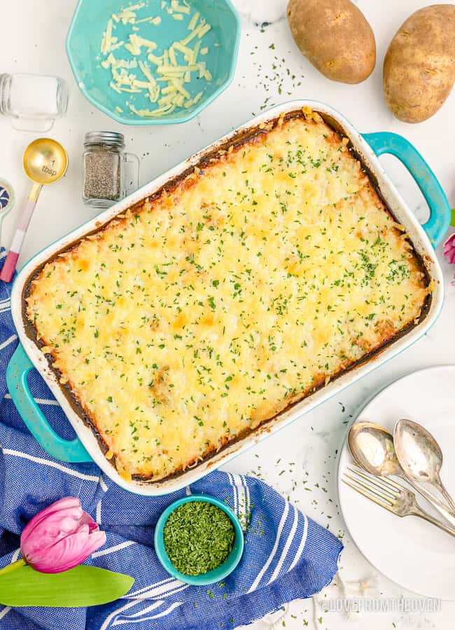 a pan of cheese scalloped potatoes on a white table