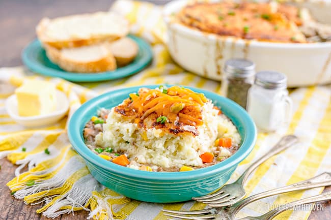 A bowl of shepards pie on a yellow and white napkin