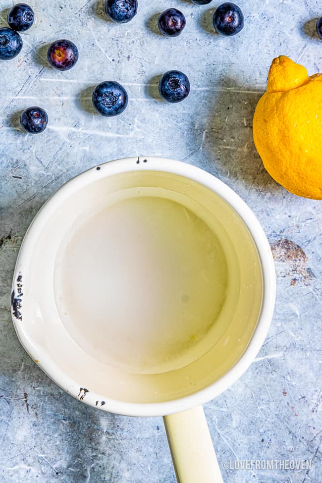 a white pan next to blueberry and a lemon