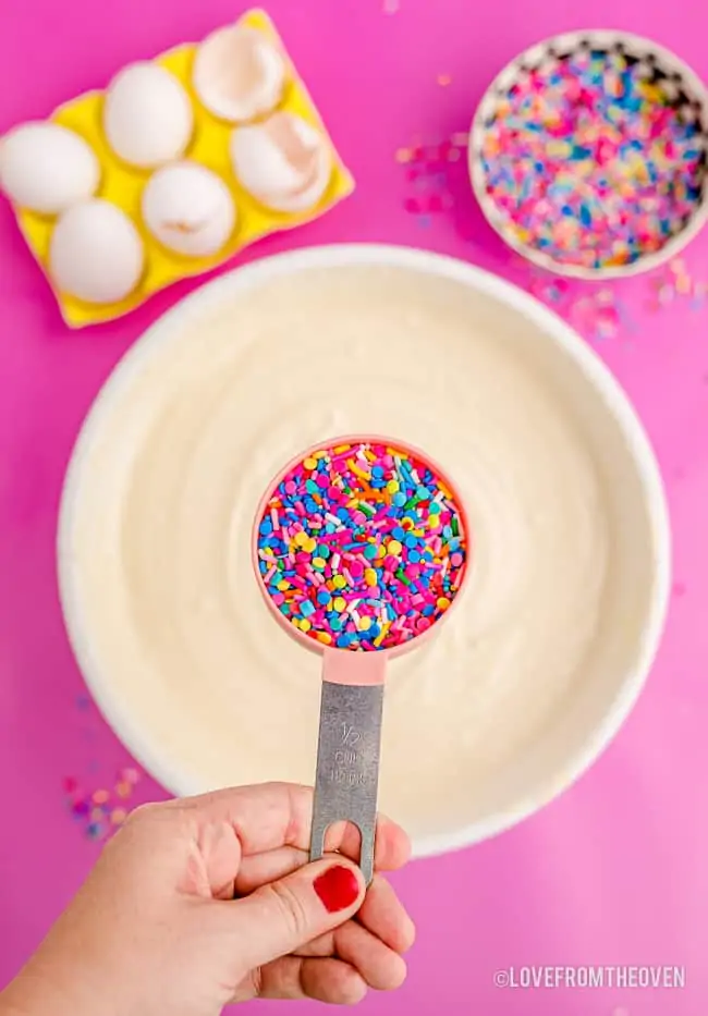 sprinkles going into a bowl of cake batter
