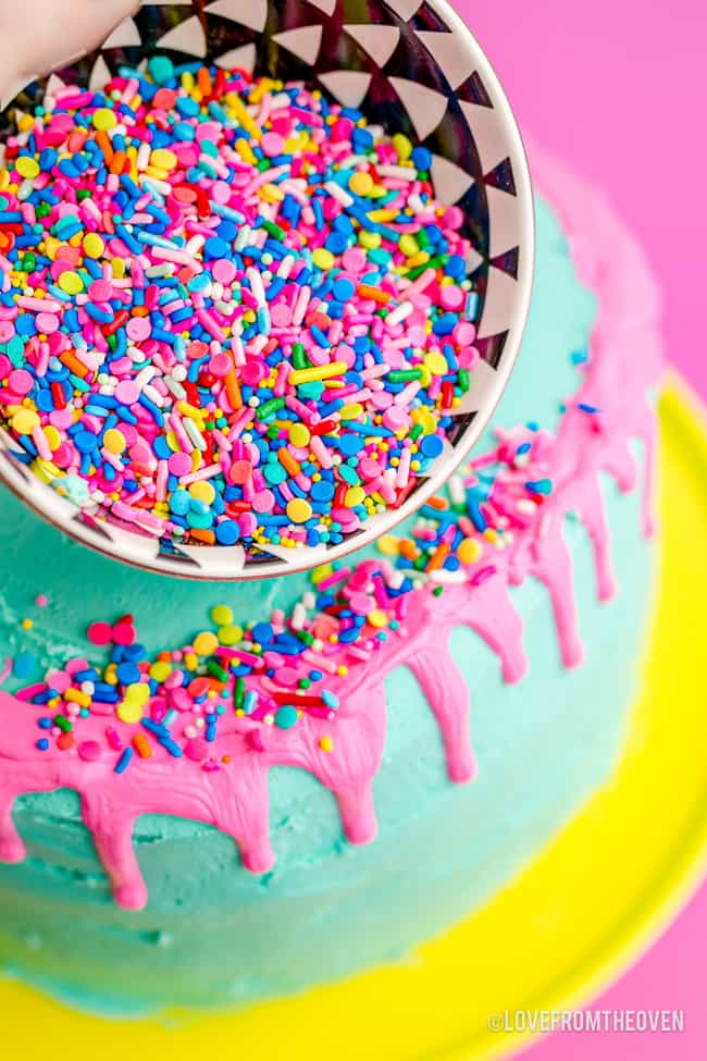 sprinkles being poured on a cake