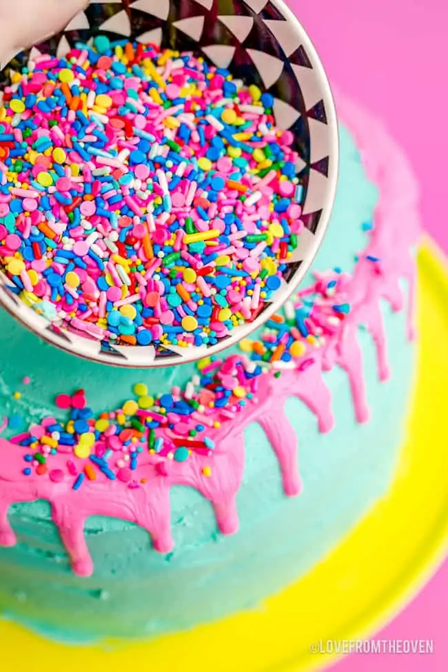 sprinkles being poured on a cake