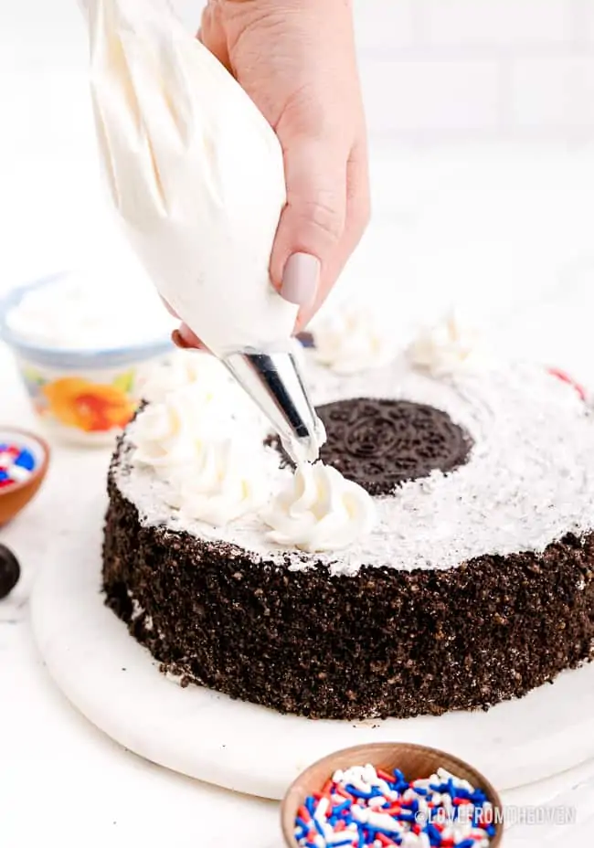 adding frosting to an ice cream cake