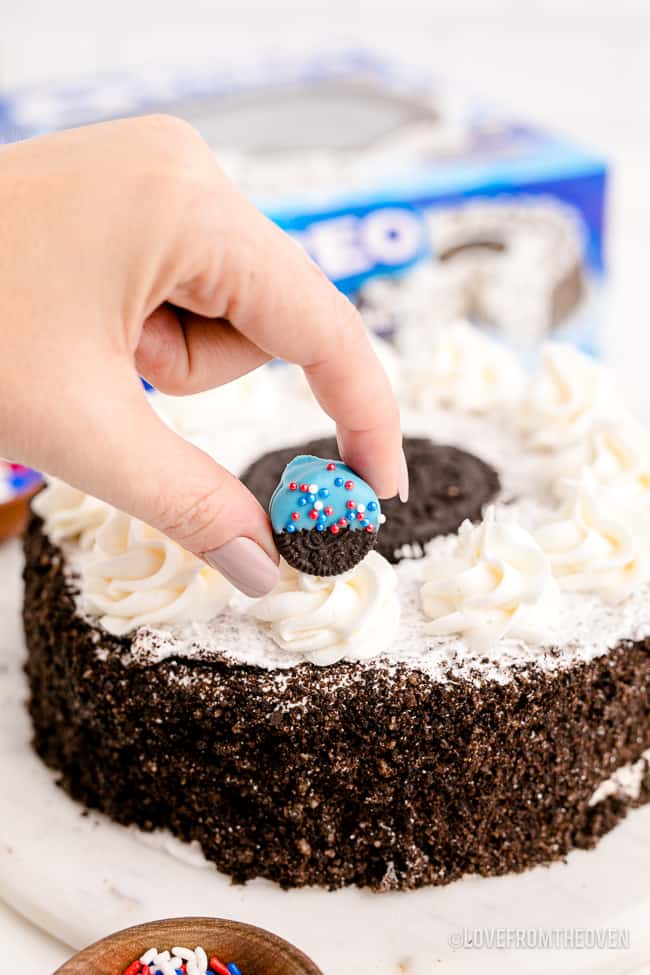 a hand decorating a store bought cake