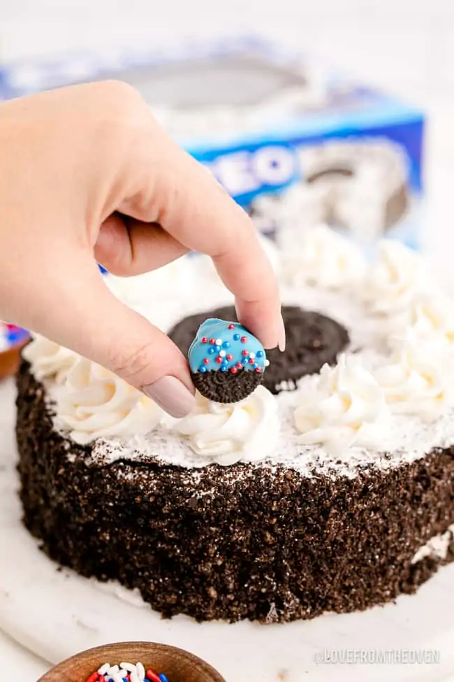 a hand decorating a store bought cake