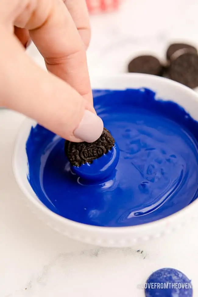 an oreo being dipped in chocolate