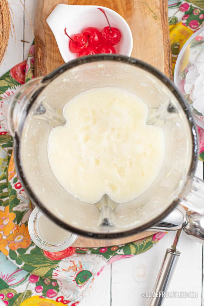 An overhead photo of a frozen pina colada in a blender.