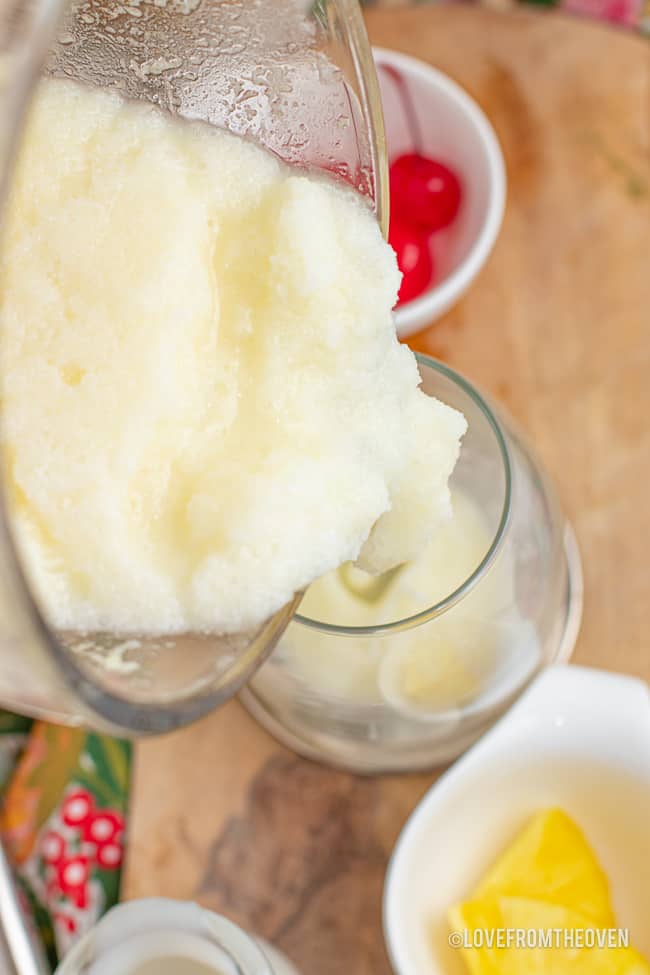 A frozen pina colada being poured into a glass.