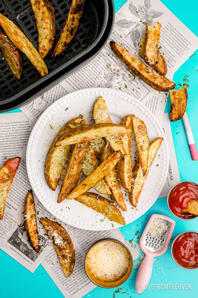 Potato wedges on a plate and in an air fryer.