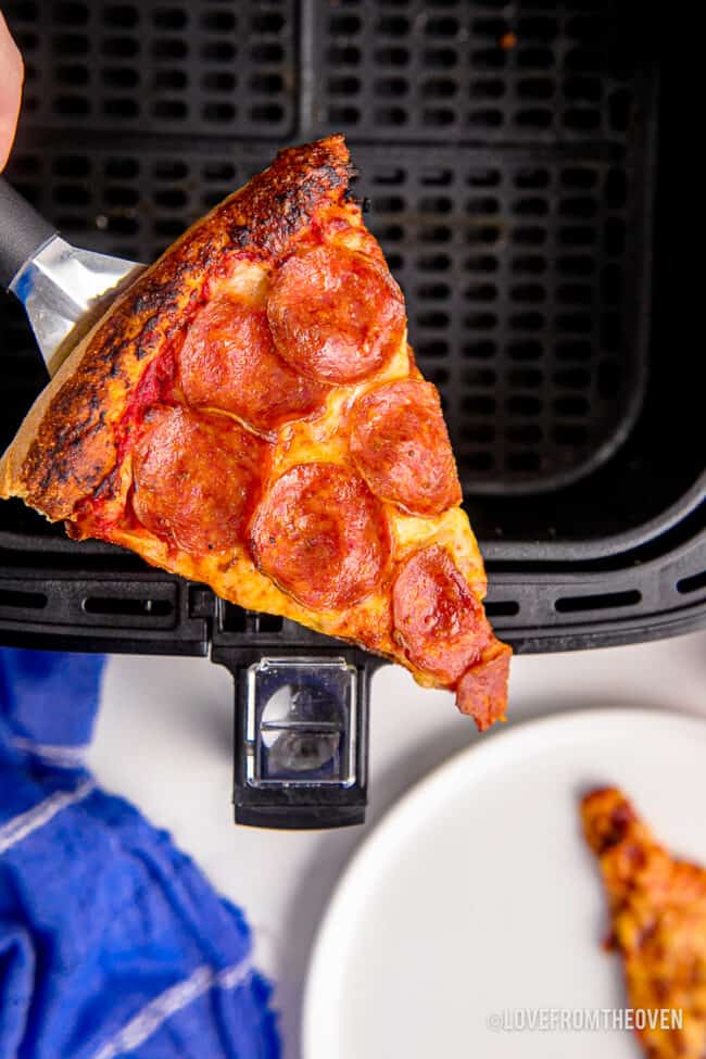 A slice of pizza in an air fryer.