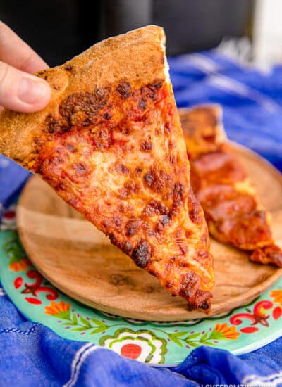 A piece of leftover pizza that has been reheated in an air fryer.