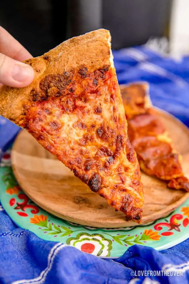 A slice of pizza on a blue background. 