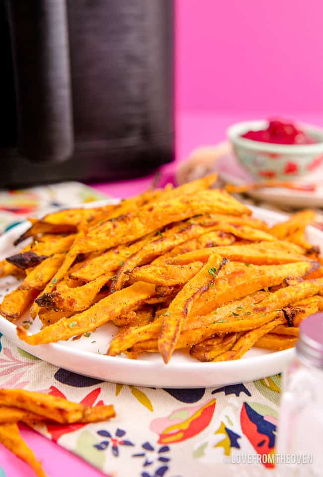 Sweet potato fries in front of an air fryer.