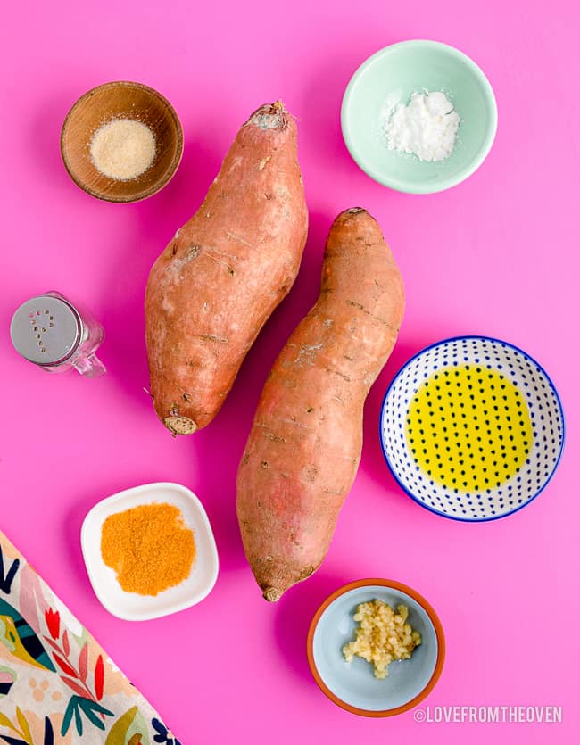 Ingredients for air fryer sweet potato fries on a pink background.
