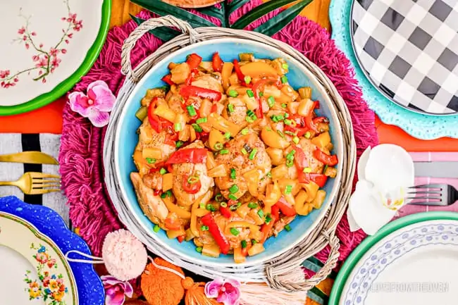 A colorful table with Crockpot Hawaiian Chicken on a plate.