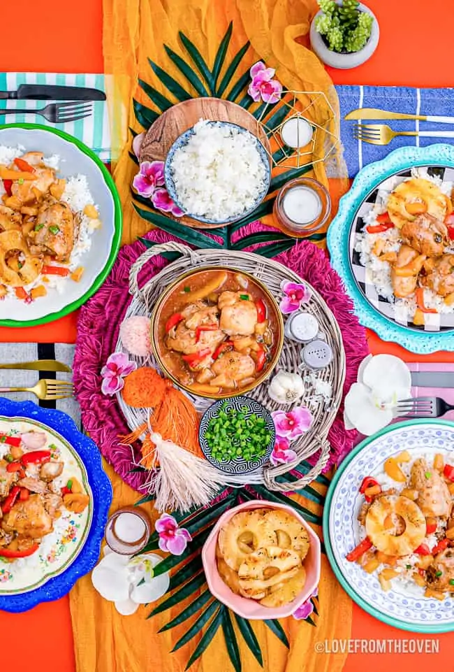 A colorful dinner table with crockpot Hawaiian chicken being served.
