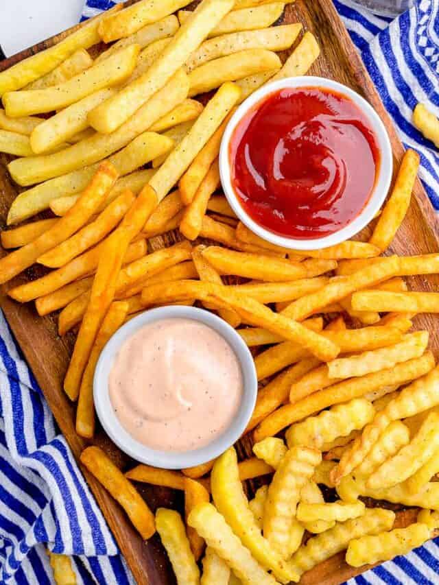 a variety of french fries on a platter with dipping sauces.