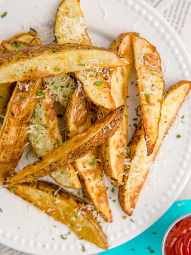 A plate full of potato wedges.